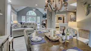 A dining area with a wooden table set for a meal, surrounded by chairs.