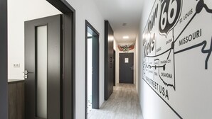 A hallway with a wall mural of Route 66, a door with a frosted glass panel, and a wooden floor. - Motel Eldorado (Mikulov)