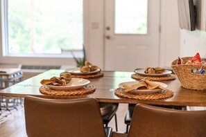 A dining table set with plates, napkins, and a basket of condiments. - GrandLake*Kayak*ForestView*Firepit*Kings*Lakefront (Grove)