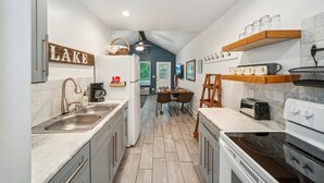 Une cuisine moderne équipée d’un évier, d’une cuisinière et d’un coin repas.