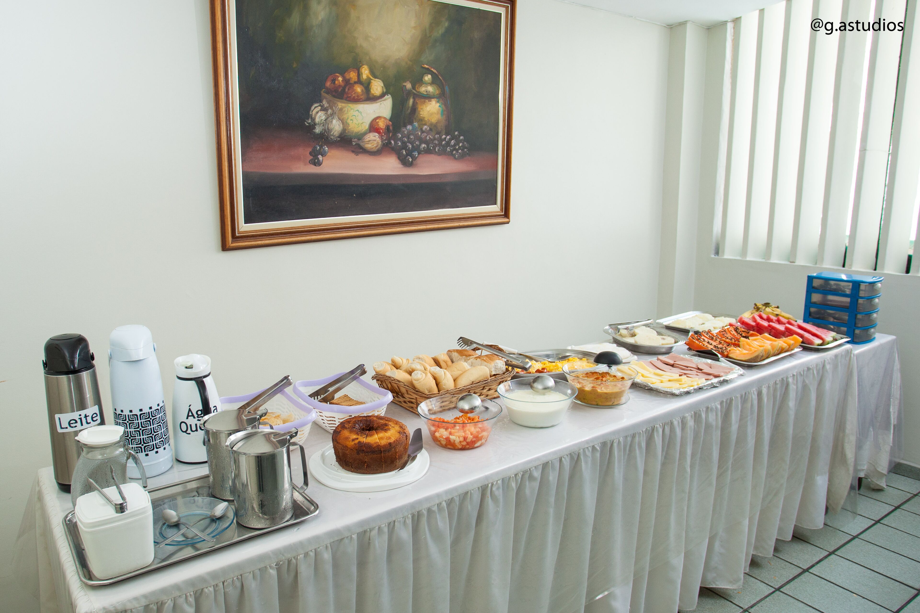 A buffet table with various food items and kitchenware.