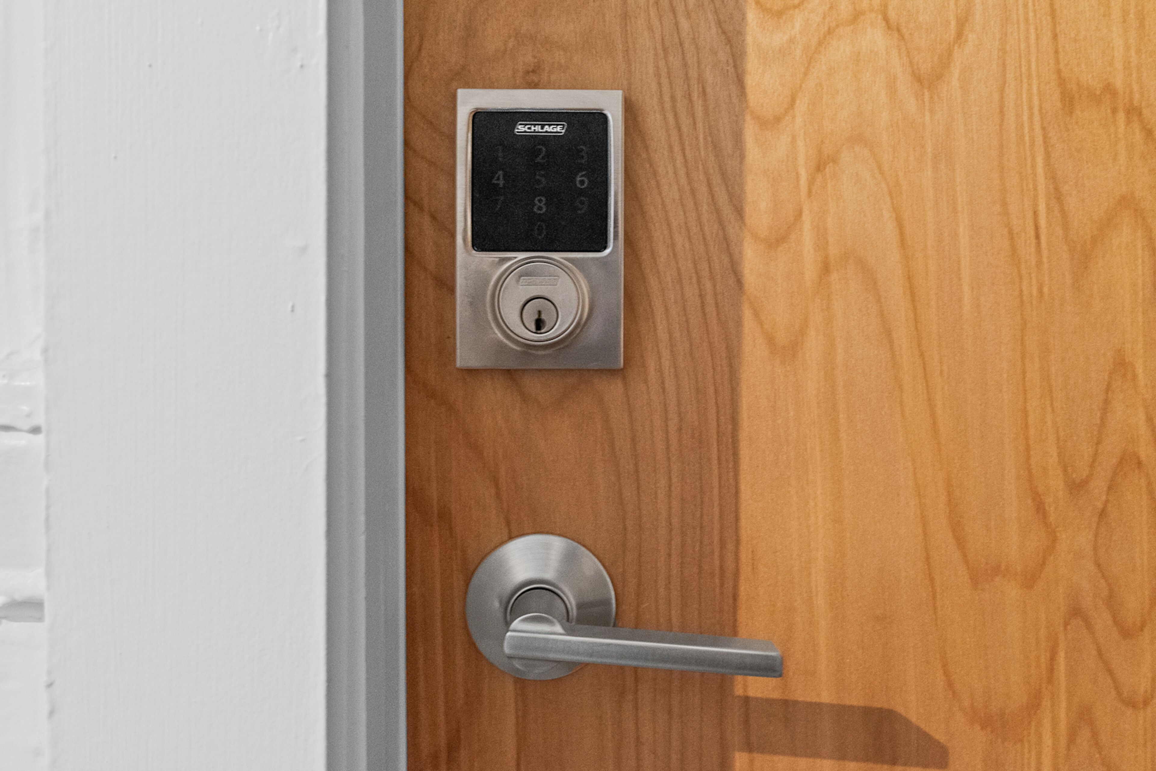A door with a numeric keypad lock and a lever handle.