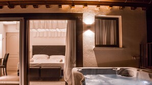 A room with a bed, a hot tub, and a sliding glass door leading to a balcony. - Hotel Boutique Castiglione del Lago (Castiglione del Lago)