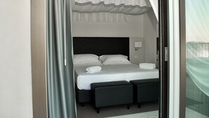 A modern hotel room with a large bed, two bedside tables, a headboard, and a window with a view. - Hotel Boutique Castiglione del Lago (Castiglione del Lago)