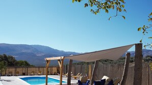 A backyard with a swimming pool, outdoor furniture, and a pergola providing shade. - Villa with private pool,  Mountain views and easy access to visit Andalucia  (Villanueva del Trabuco)