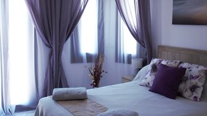 A bedroom with a bed, a nightstand, a lamp, and a painting on the wall. - Villa with private pool,  Mountain views and easy access to visit Andalucia  (Villanueva del Trabuco)