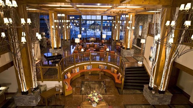 A spacious lobby with a central seating area, a piano, and a staircase leading to an upper level. - Luxury Studio Ski-in Ski-Out, Hiking, Mtn Biking, Golf, Fishing (Stowe)