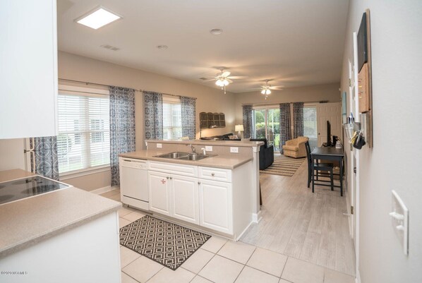 Enjoy meals in the kitchen with a central island and sink, adjacent to a dining area with a table and chairs.