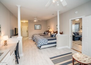 Relax in this serene bedroom with a large bed, bedside tables, and a ceiling fan.