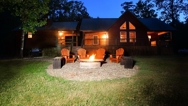 A wooden cabin with a fire pit and outdoor seating. - The Wild Buck, A Secluded Cabin that Borders the National Forest (Broken Bow)