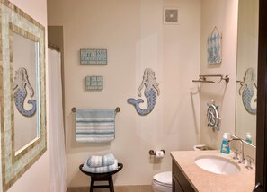 Een bad/douchecombinatie, een haardroger, handdoeken, toiletpapier