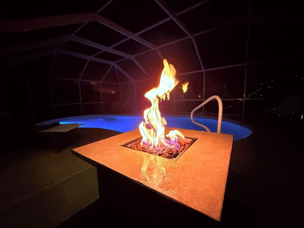 A pool with a square fire feature in the center.