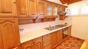 Una cocina con armarios de madera, un lavamanos de acero inoxidable y un horno empotrado.