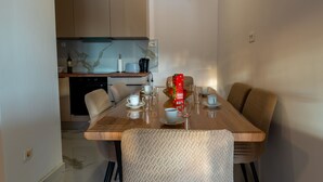 A dining area with a wooden table set for four, surrounded by cushioned chairs. - Apartments Peselj-Three Bedroom Apartment with Terrace and Sea View (Smokvica)