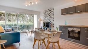 A modern kitchen with a dining area, large windows, and a geometric backsplash. - Les Gemeaux by Interhome (Quiberon)