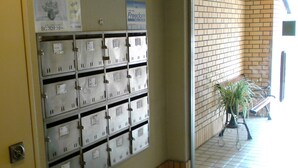 A row of metal lockers with labels, a tiled floor, and a brick wall. - Ichijyo-IVY Bunk bed twin (Kyoto)