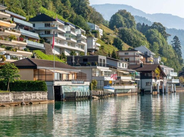 A waterfront residential area with modern houses, a dock, and a flag.
