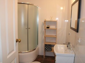 A bathroom with a shower, toilet, and sink.