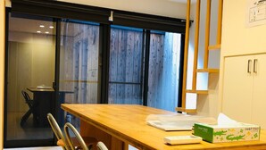 A modern kitchen with a wooden table, chairs, and a clock on the wall. - Ichijyo PREMIUM (Kyoto)