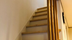 A wooden staircase with a handrail, leading to an upper floor. - Ichijyo PREMIUM (Kyoto)