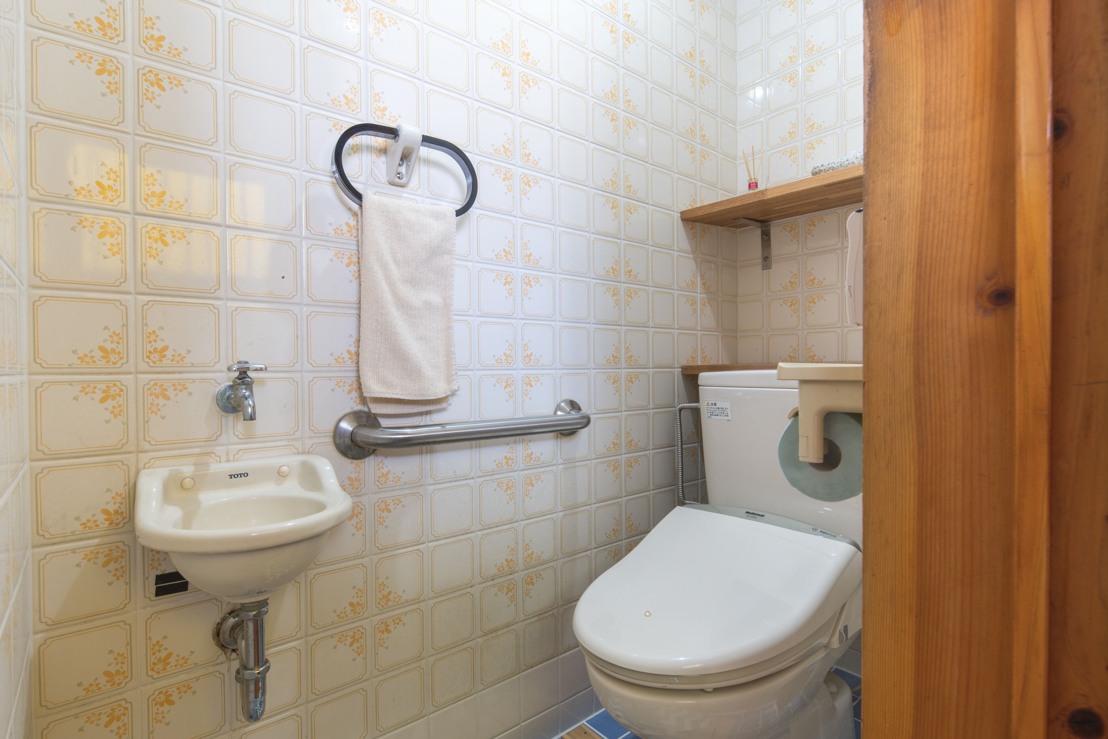 A bathroom with a toilet, sink, and a towel rack.