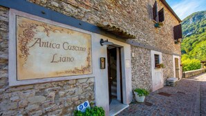 Ein Steinhaus mit einem Schild, auf dem 'Antica Cascina Liano' steht.