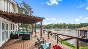 A wooden deck with outdoor seating, overlooking a body of water. - 5 STAR VIEWS! Boat rental! Chef's kitchen! SUP/kayak/game room/mauimat (Murchison)