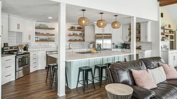 A modern kitchen with white cabinetry, a central island with stools, and pendant lighting. - 5 STAR VIEWS! Boat rental! Chef's kitchen! SUP/kayak/game room/mauimat (Murchison)