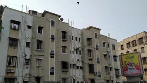 Un immeuble à plusieurs étages, doté d’une rangée de fenêtres et de balcons. Un passage piéton se trouve devant l’immeuble.