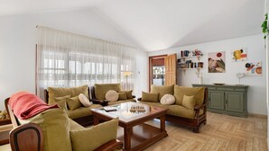 A living room with a sofa set, a coffee table, and a bookshelf. - Beachside Villa "Muñoz" with Heated Pool, Air Conditioning & Wi-Fi (Puerto del Carmen)