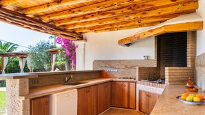 A kitchen with wooden cabinets, a built-in oven, and a stone countertop.
