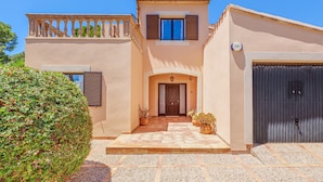 A two-story house with a balcony, a front door, and a garage. - Vacation Home Villa Karen with Pool & Wi-Fi (Sa Rapita)