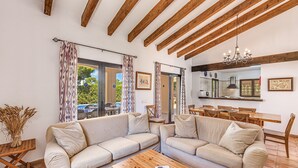 A living room with two sofas, a wooden coffee table, and a dining area with a table and chairs. - Vacation Home Villa Karen with Pool & Wi-Fi (Sa Rapita)