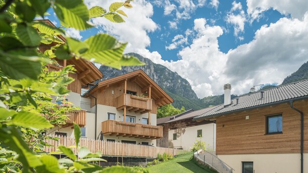A multi-story wooden building with balconies, a wooden fence, and a mountain backdrop. - Holiday Apartment "Roderer" with Mountain View, Wi-Fi, Balconies & Terrace (Völs)