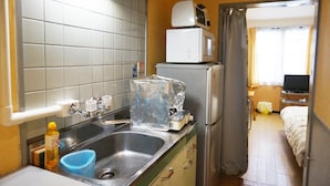 A compact kitchen with a sink, a microwave, and a refrigerator. - Gojyo-IVY Semi-double bed 1 (Kyoto)