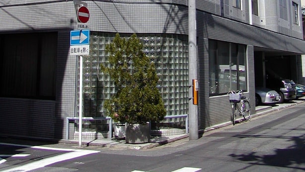A modern building with a grid-like facade, a no entry sign, and a directional sign. - Gojyo-IVY Semi-double bed 1 (Kyoto)