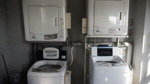 A laundry room with two washing machines and a dryer, connected by pipes and hoses. - Gojyo-IVY Semi-double bed 1 (Kyoto)