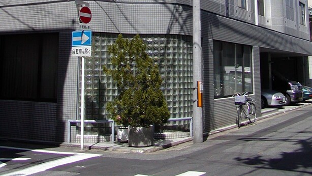 A modern building with a grid-like facade, a no entry sign, and a directional sign. - Gojyo-IVY Twin bed 2 (Kyoto)
