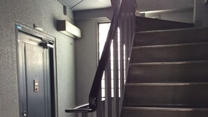 A staircase with a metal handrail and a door with a keypad lock. - Gojyo-IVY Twin bed 2 (Kyoto)