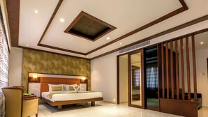 A modern hotel room with a large bed, a ceiling skylight, a sliding glass door, and a wooden floor. - The Fern Residency, Vijayapura (Bijapur)