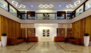 A spacious lobby with a high ceiling, two levels of seating, and modern lighting fixtures. - The Fern Residency, Vijayapura (Bijapur)