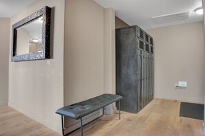 A hallway with a bench, a mirror, and a door leading to a utility room.