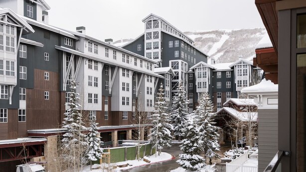 A snow-covered building complex with multiple buildings, a river, and snow-laden trees.