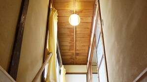 Una escalera de madera con una lámpara en la parte superior.