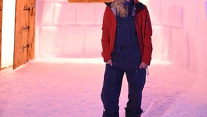 A person standing in front of an igloo-shaped structure with a sign that reads "IGLU-DUO HOTEL EXHIBIT".
