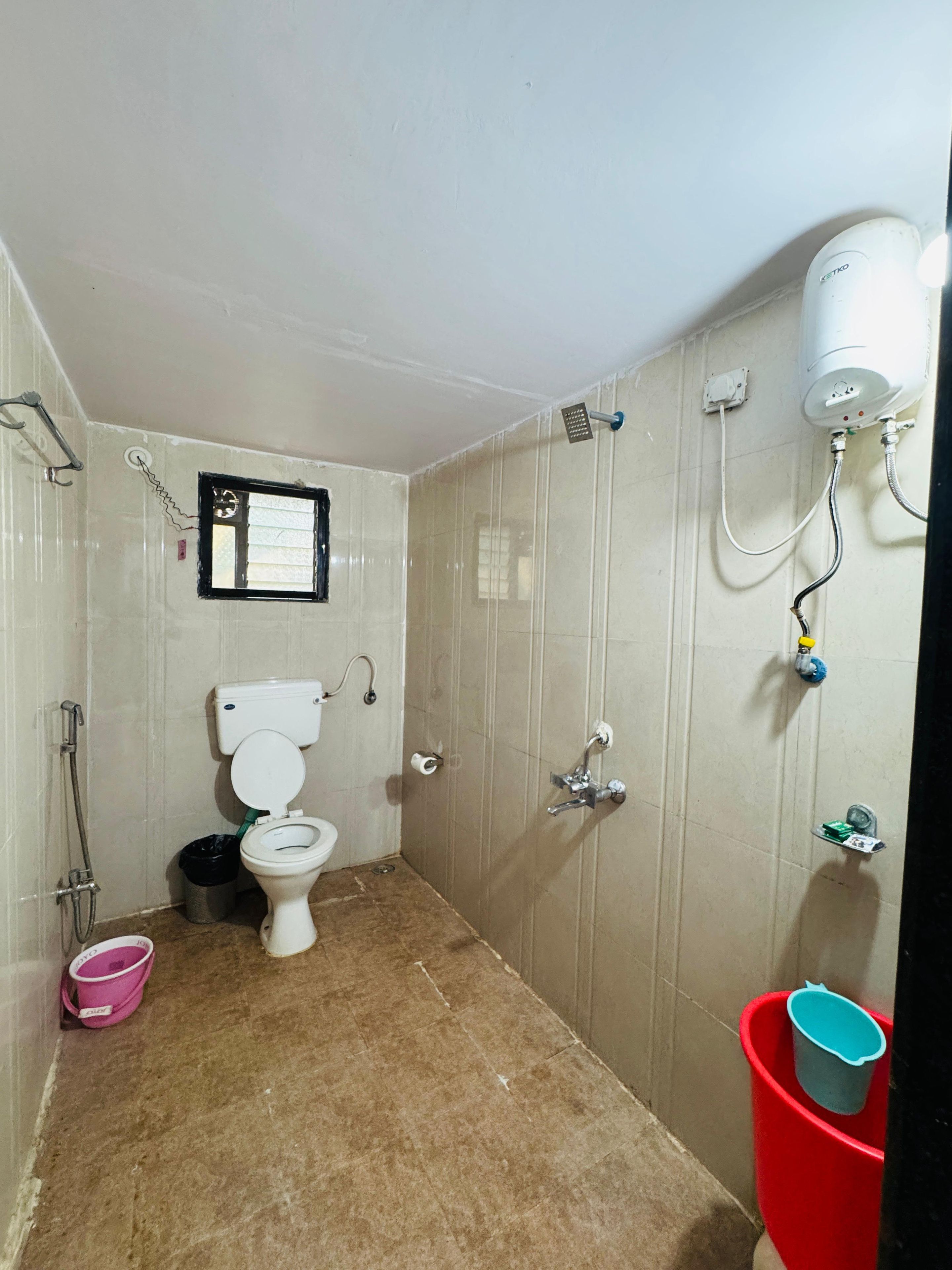Un baño pequeño con inodoro, ducha y secador de manos.