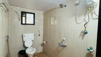 Un baño pequeño con inodoro, ducha y secador de manos.