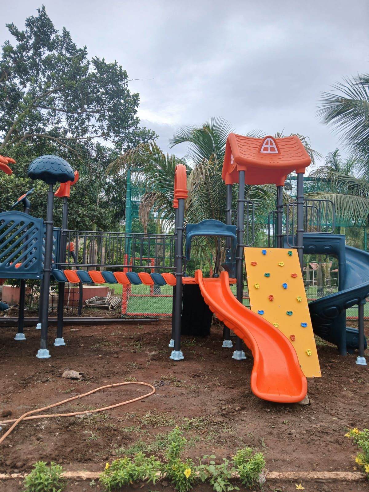 A playground with a slide, climbing wall, and various play structures.