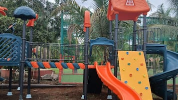 A playground with a slide, climbing wall, and various play structures.