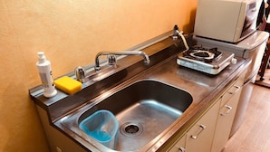 A kitchen with a stainless steel sink, a microwave, and a gas stove. - Nishijin-IVY Bunk bed twin (Kyoto)